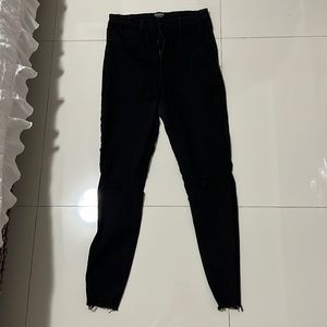 Black stretchy skinny jeans with rips at knees